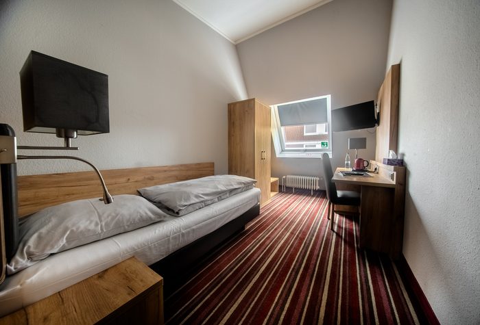 Einzelzimmer mit Bett und Flachbild-TV